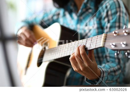 Skillful musician fingers on guitar fretboard 63002026