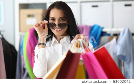 Woman adjusts glasses from sun showing packages 63002041