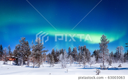 Aurora Borealis over winter wonderland scenery in Scandinavia Aurora Borealis over winter wonderland scenery in Scandinavia 63003063