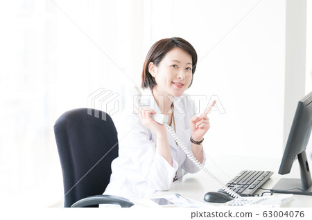 White coat woman desk work White coat woman desk work 63004076