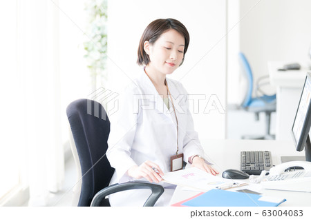White coat woman desk work White coat woman desk work 63004083