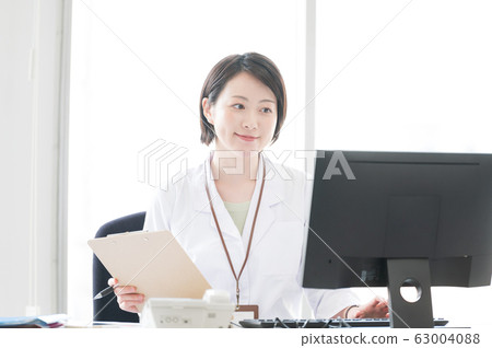 White coat woman desk work White coat woman desk work 63004088