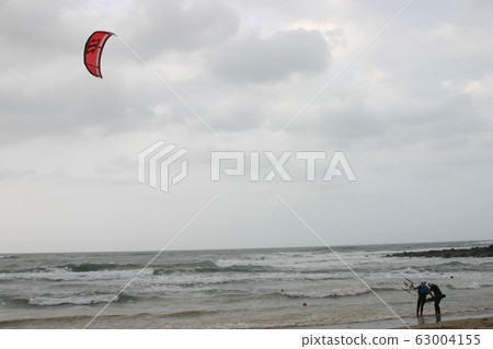 People playing Kitesurfing on a storm day 63004155