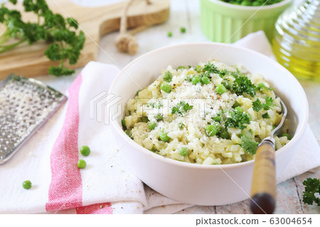 Italian cuisine. Plate of green pea risotto with green pea, grated parmesan cheese, olive oil and parsley 63004654