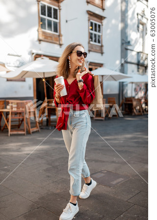 Lifestyle portrait of a woman with coffee in the old town 63005076