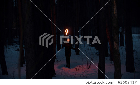 Young woman with torch walking in the night winter forest Young woman with torch walking in the night winter forest 63005487