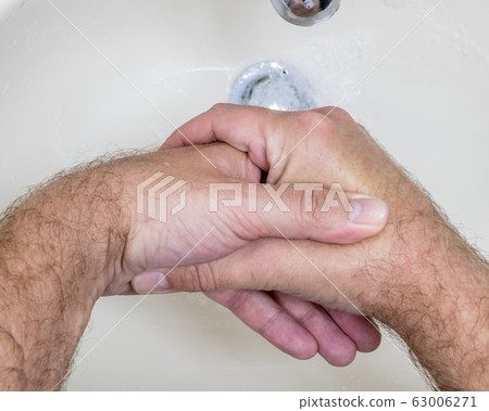 Man washing hands close-up from above Man washing hands close-up from above 63006271