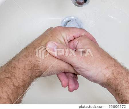 Man washing hands close-up from above Man washing hands close-up from above 63006272
