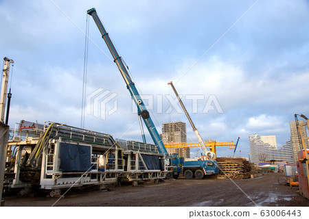 Mobile auto cranes working at construction site. Mobile auto cranes working at construction site. 63006443