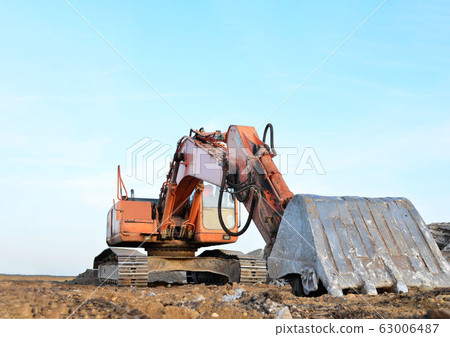 Red tracked excavator at a open-pit mining. Red tracked excavator at a open-pit mining. 63006487
