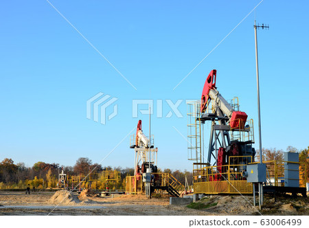Oil drilling derricks at desert oilfield for fossil fuels output and crude oil production 63006499