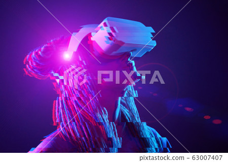 Woman is using virtual reality headset. Neon light studio portrait. Image with glitch effect. 63007407