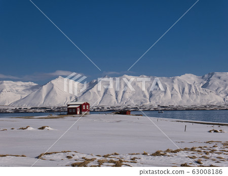 Red house on the coast in front of snowy mountains Red house on the coast in front of snowy mountains 63008186