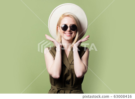 Style blonde woman in sunglasses, hat and sundress 63008416