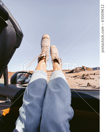 Woman traveling by convertible car on the desert valley 63009612
