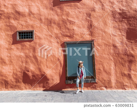 Woman on the red wall background Woman on the red wall background 63009831