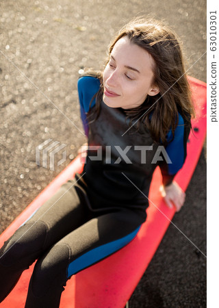 Relaxed surfer with surfboard on the beach Relaxed surfer with surfboard on the beach 63010301