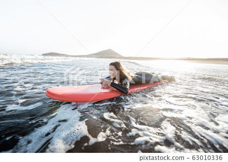 Woman swimming on the surfboard 63010336