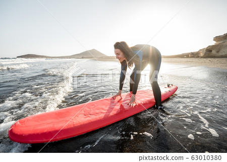 Woman surfing in the sea Woman surfing in the sea 63010380