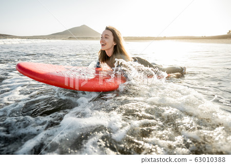 Woman swimming on the surfboard Woman swimming on the surfboard 63010388