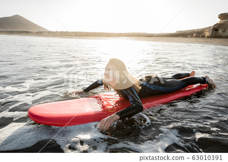Woman swimming on the surfboard Woman swimming on the surfboard 63010391