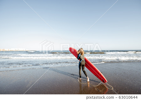 Woman with surfboard on the beach 63010644
