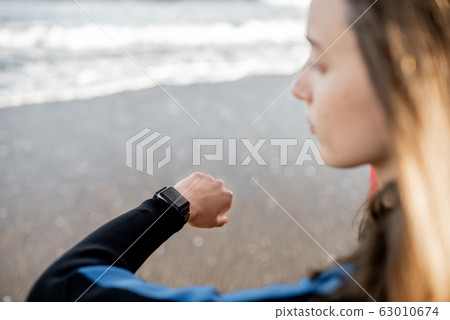 Surfer using smart watch 63010674