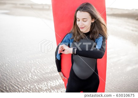 Young surfer with surfboard on the beach 63010675