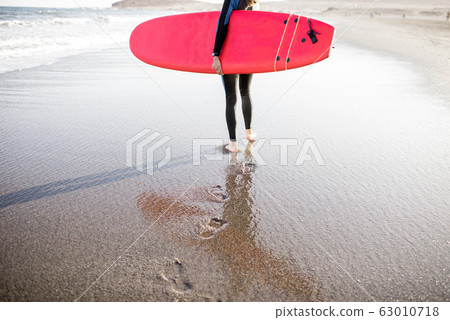 Young surfer with surfboard on the beach Young surfer with surfboard on the beach 63010718