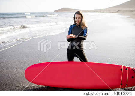 Young surfer with surfboard on the beach Young surfer with surfboard on the beach 63010726