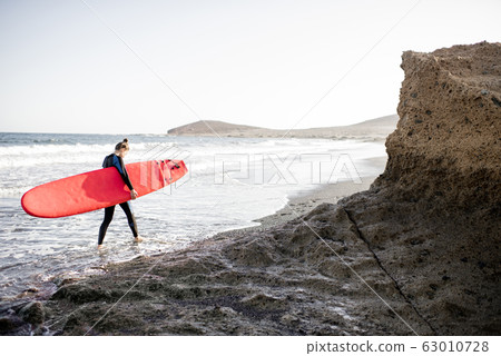 Surfer on the rocky coast Surfer on the rocky coast 63010728