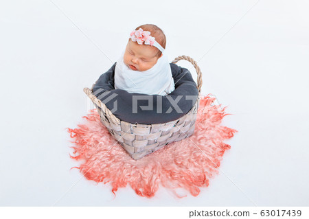 newborn baby wrapped in a blanket sleeping in a basket. concept of childhood, healthcare, IVF. newborn baby wrapped in a blanket sleeping in a basket. concept of childhood, healthcare, IVF. 63017439