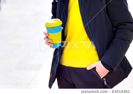 Female hands hold reusable coffee mug. Take your coffee to-go with reusable mug. Female hands hold reusable coffee mug. Take your coffee to-go with reusable mug. 63018362