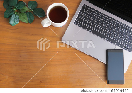 Laptop, smartphone, coffee and green placed on wood grain desk 63019463