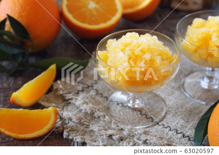 Orange granita, frozen summer dessert and fresh orange fruits 63020597