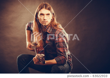 Guitarist trying out chords. Guitarist trying out chords. 63022910