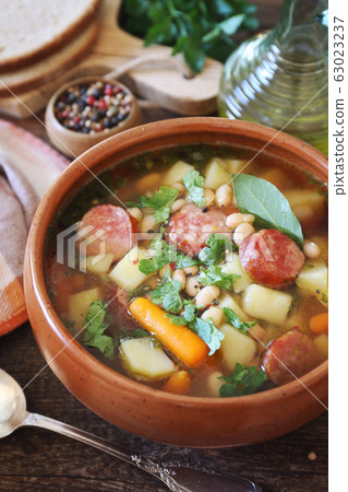Spanish cuisine. Caldo gallego: traditional bean soup with seasonal vegetables and sausages 63023237