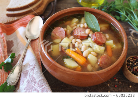 Spanish cuisine. Caldo gallego: traditional bean soup with seasonal vegetables and sausages 63023238