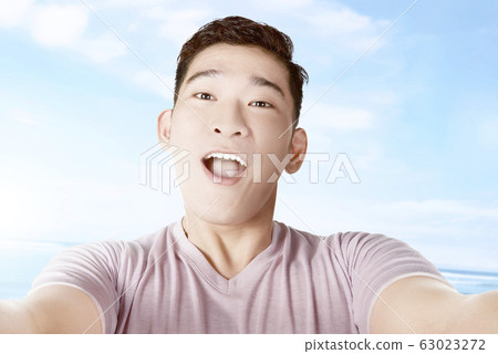 Asian man making selfie using the camera phone 63023272