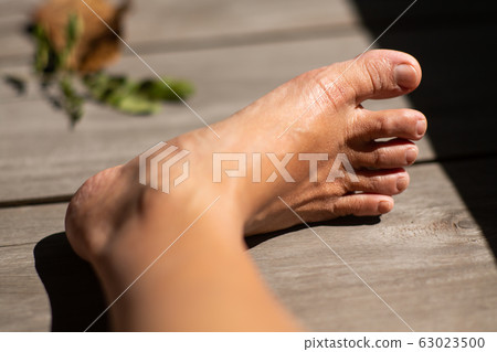 Women's second toes, middle toe, fourth toe crooked, In wooden background, Close up & Macro shot, Selective focus, Asian Body skin part, Healthcare concept Women's second toes, middle toe, fourth toe crooked, In wooden background, Close up & Macro shot, Selective focus, Asian Body skin part, Healthcare concept 63023500
