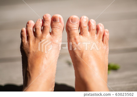 Women's second toes, middle toe, fourth toe crooked, In wooden background, Close up & Macro shot, Selective focus, Asian Body skin part, Healthcare concept Women's second toes, middle toe, fourth toe crooked, In wooden background, Close up & Macro shot, Selective focus, Asian Body skin part, Healthcare concept 63023502