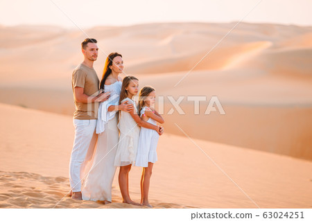 Family among dunes in Rub al-Khali desert in United Arab Emirates 63024251