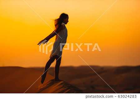 Girl among dunes in Rub al-Khali desert in United Arab Emirates 63024283