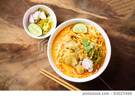 Spicy curry noodles soup with coconut milk and chicken in a bowl, Northern Thai food 63025489