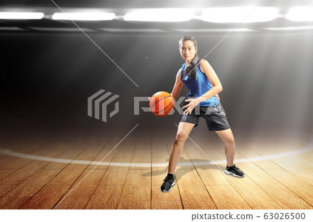 Asian woman basketball player in action with the ball Asian woman basketball player in action with the ball 63026500