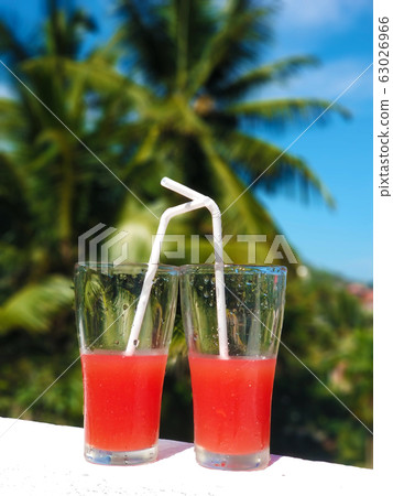 Two glass glasses with freshly squeezed juice and Two glass glasses with freshly squeezed juice and 63026966