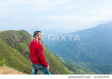 A man enjoying the mountain scenery on the edge of A man enjoying the mountain scenery on the edge of 63026978
