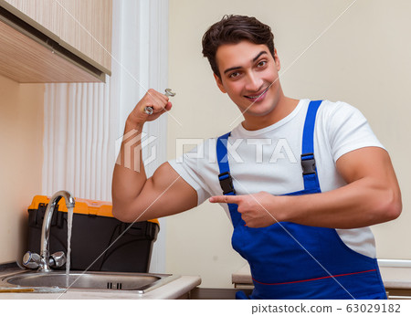 Young repairman working at the kitchen 63029182