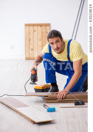 Young male contractor working indoors Young male contractor working indoors 63029614