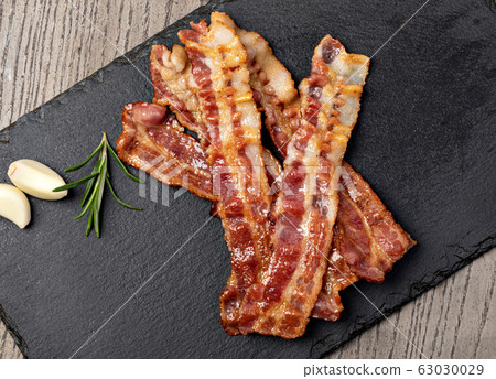 Closeup of slices of crispy hot fried bacon 63030029